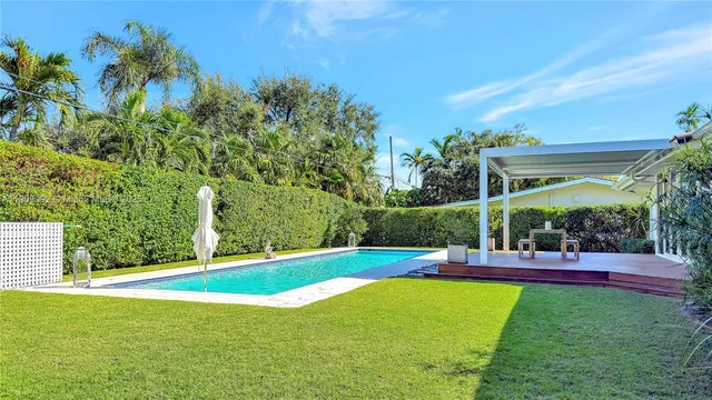 a swimming pool with outdoor seating and yard