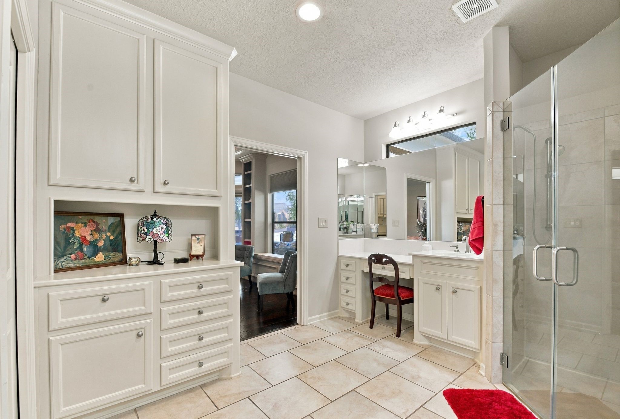 20341 Bay Hill Road Point Blank, TX 77364 - Photo 24 of 50 Spacious bathroom features elegant cabinetry, a glass-enclosed shower, and a cozy vanity area, creating a luxurious and functional space.