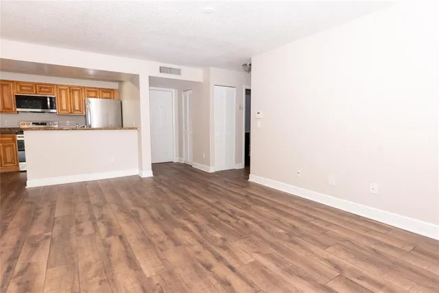 a view of a kitchen with wooden floor and a sink