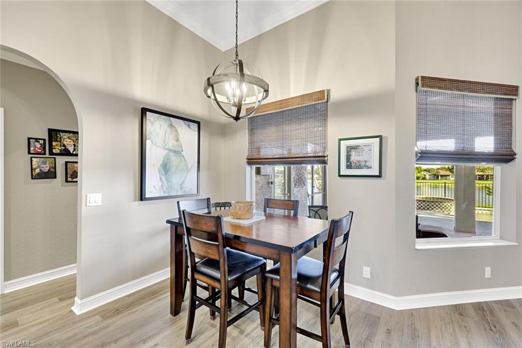 2143 Grove Drive Naples, FL 34120 - Photo 10 of 35 a view of a dining room with furniture a chandelier and wooden floor