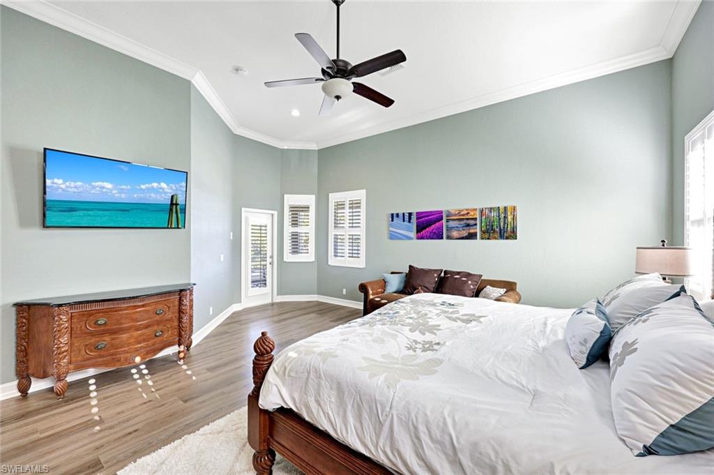 2143 Grove Drive Naples, FL 34120 - Photo 13 of 35 a bedroom with a bed and a dresser with wooden floor