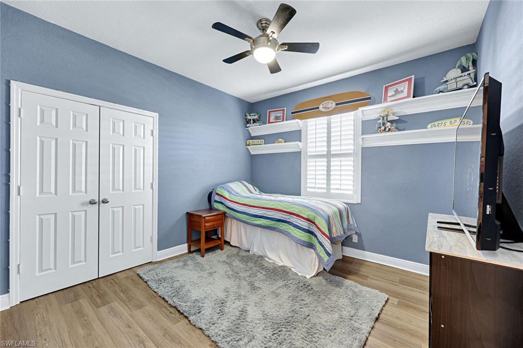 2143 Grove Drive Naples, FL 34120 - Photo 19 of 35 a bedroom with a bed and a chandelier