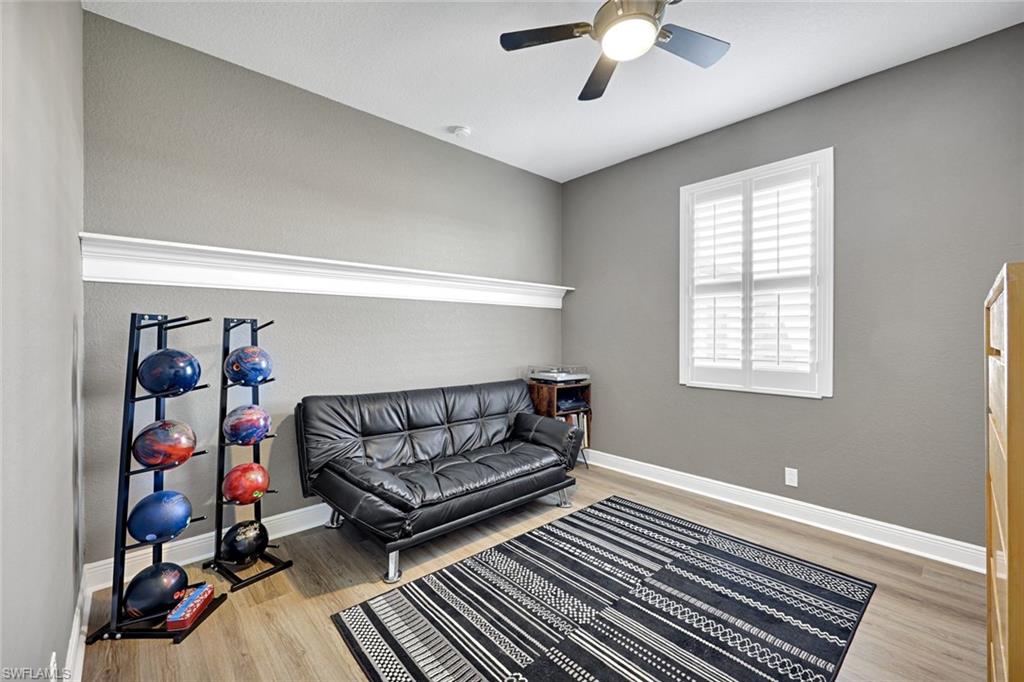 2143 Grove Drive Naples, FL 34120 - Photo 22 of 37 Guest bedroom 3 is being used as a sitting room with light wood-style floors and a ceiling fan