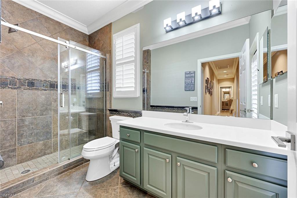 2143 Grove Drive Naples, FL 34120 - Photo 23 of 37 Full bathroom with crown molding, vanity, and a stall shower
