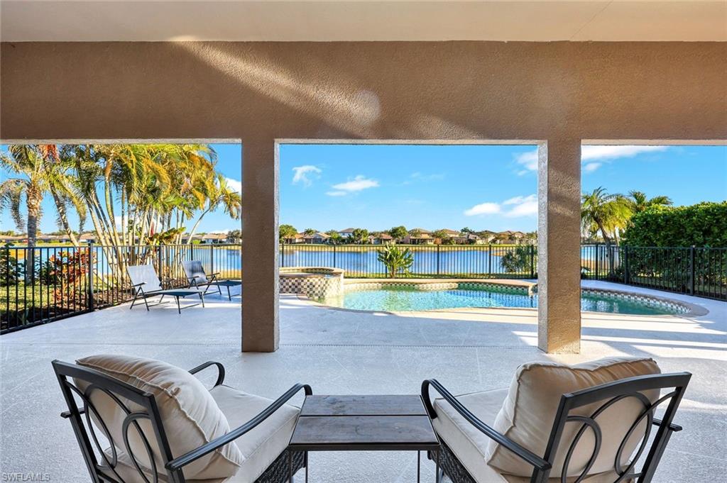 2143 Grove Drive Naples, FL 34120 - Photo 25 of 37 Fenced backyard featuring a patio, a water view, a pool with connected hot tub, and a residential view