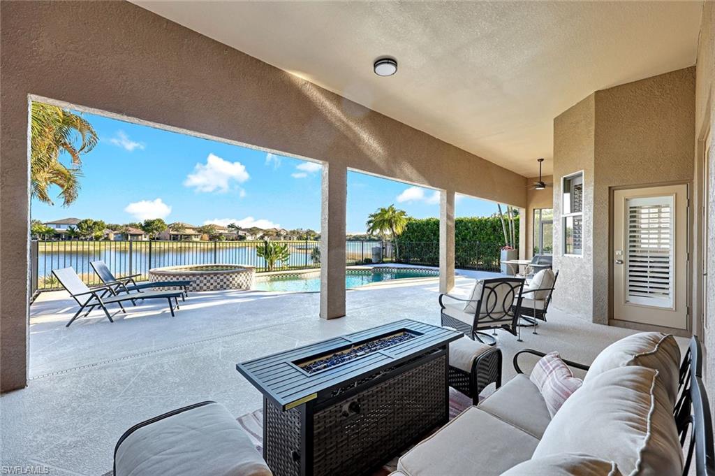 2143 Grove Drive Naples, FL 34120 - Photo 26 of 37 Fenced backyard featuring a patio, a residential view, a pool with connected hot tub, a water view, and an outdoor living space with a fire pit