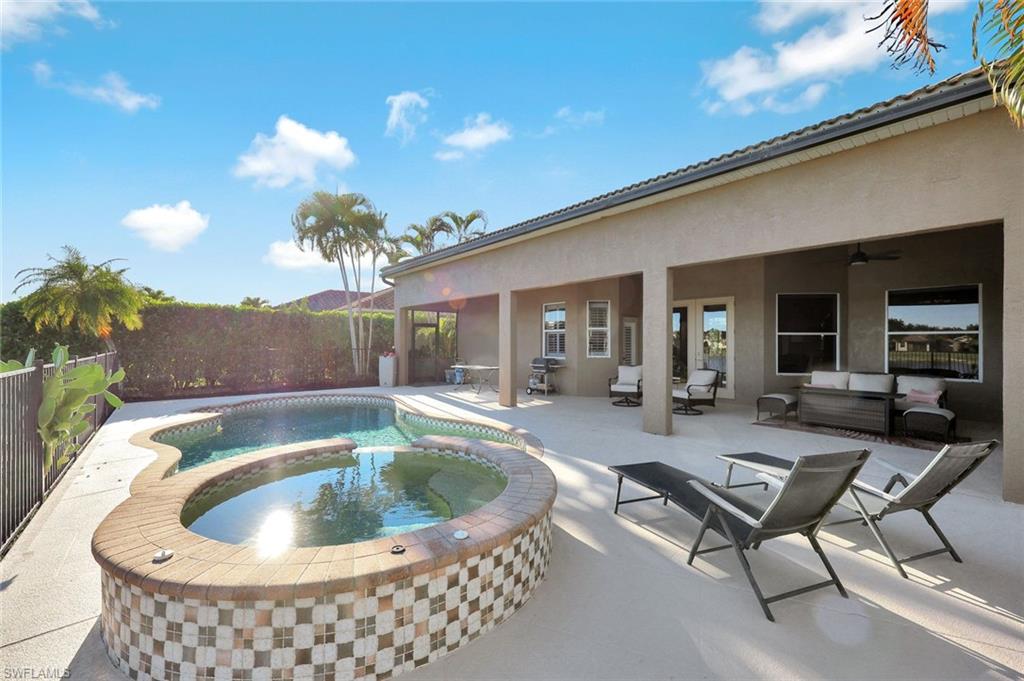 2143 Grove Drive Naples, FL 34120 - Photo 27 of 37 View of pool featuring a patio, a fenced backyard, an outdoor living space, and a pool with connected hot tub