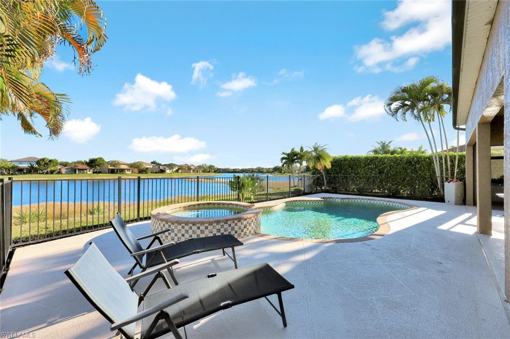 2143 Grove Drive Naples, FL 34120 - Photo 32 of 37 View of swimming pool featuring a patio area, a pool with connected hot tub, and a water view