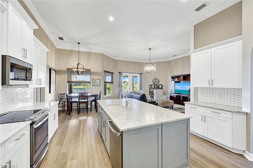2143 Grove Drive Naples, FL 34120 - Photo 8 of 35 a kitchen with stainless steel appliances kitchen island granite countertop a sink and cabinets