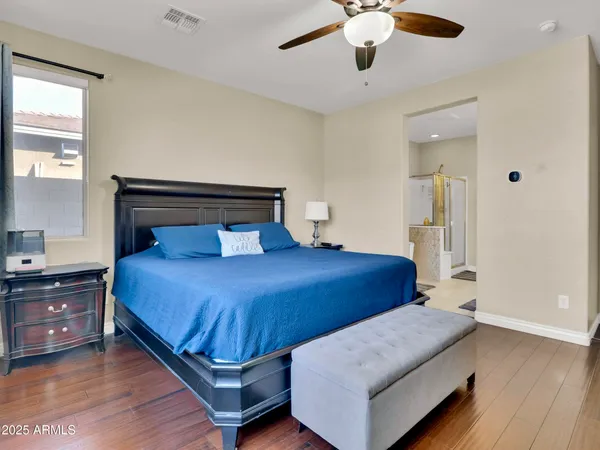 a bedroom with a large bed and ceiling fan