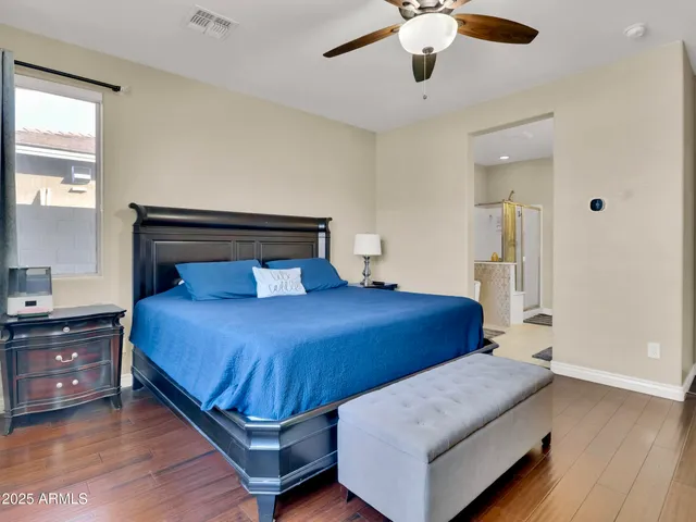 a bedroom with a large bed and ceiling fan