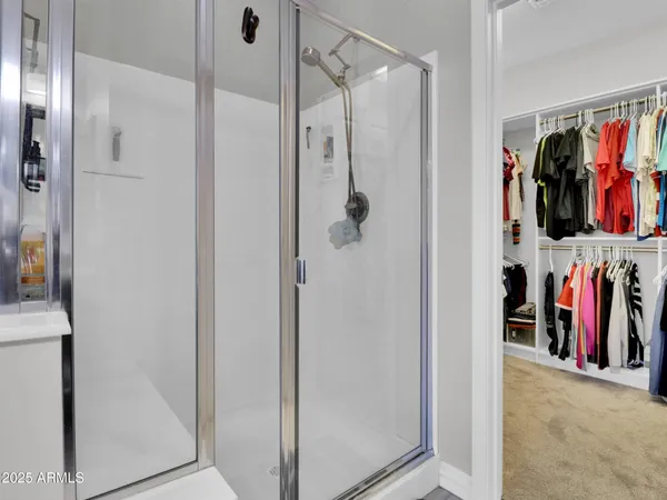 a view of walk in closet with clothes