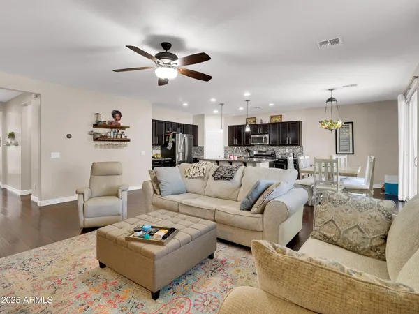 a living room with furniture kitchen view and a chandelier