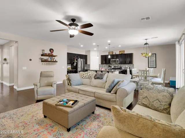 a living room with furniture kitchen view and a chandelier