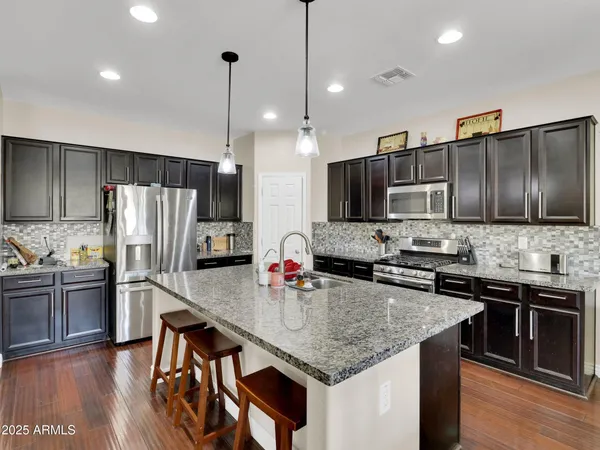 a kitchen with stainless steel appliances granite countertop a sink refrigerator and microwave