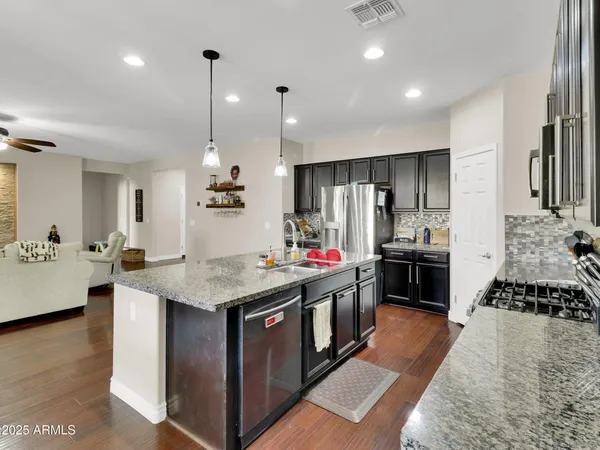 a kitchen with kitchen island granite countertop a stove oven and a refrigerator