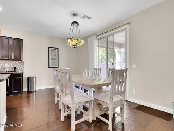 a view of a dining room with furniture a chandelier and wooden floor