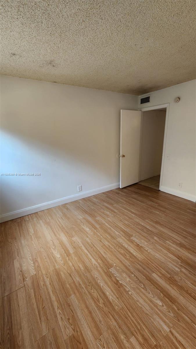 4425 Treehouse Lane, Unit B Tamarac, FL 33319 - Photo 13 of 19 a view of empty room with wooden floor