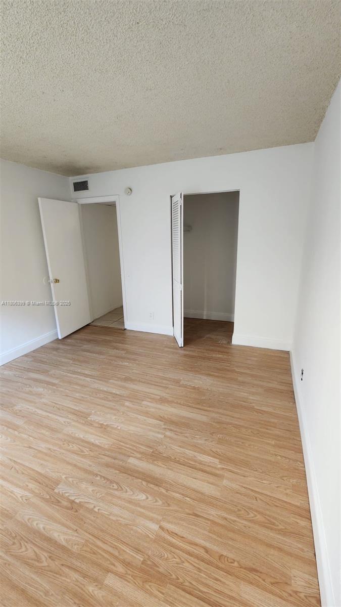 4425 Treehouse Lane, Unit B Tamarac, FL 33319 - Photo 9 of 19 a view of an empty room with wooden floor
