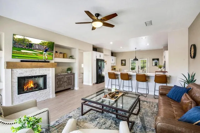 a living room with furniture kitchen view and a fireplace