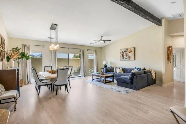 a living room with furniture wooden floor and dining table