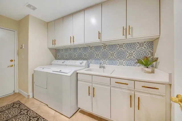 a utility room with cabinets washer and dryer