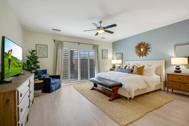 a spacious bedroom with a bed and a flat screen television