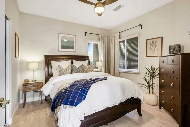 a bedroom with a large bed and a chandelier