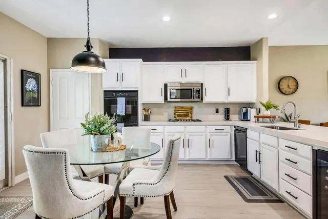 a kitchen with white cabinets and stainless steel appliances