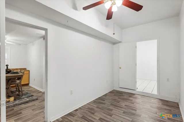a view of room with wooden floor and ceiling fan
