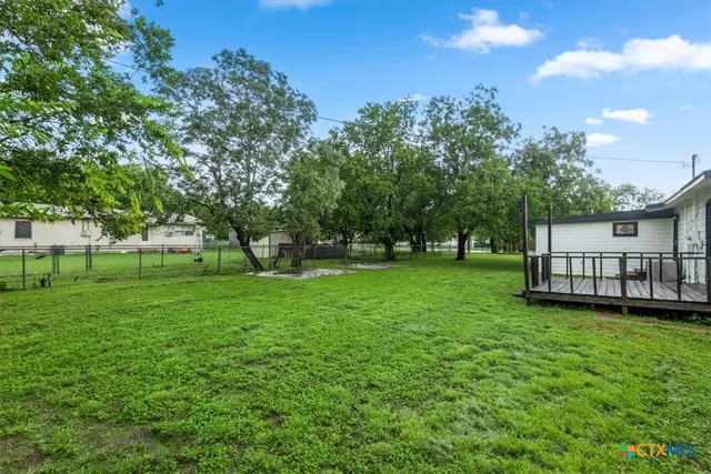 a view of yard with green space and trees