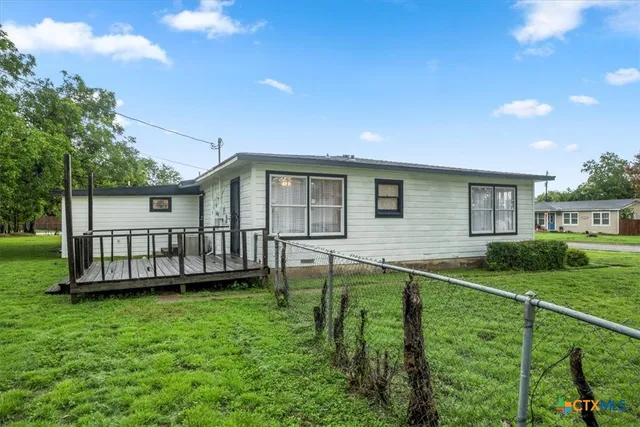 a view of a house with a yard and sitting area