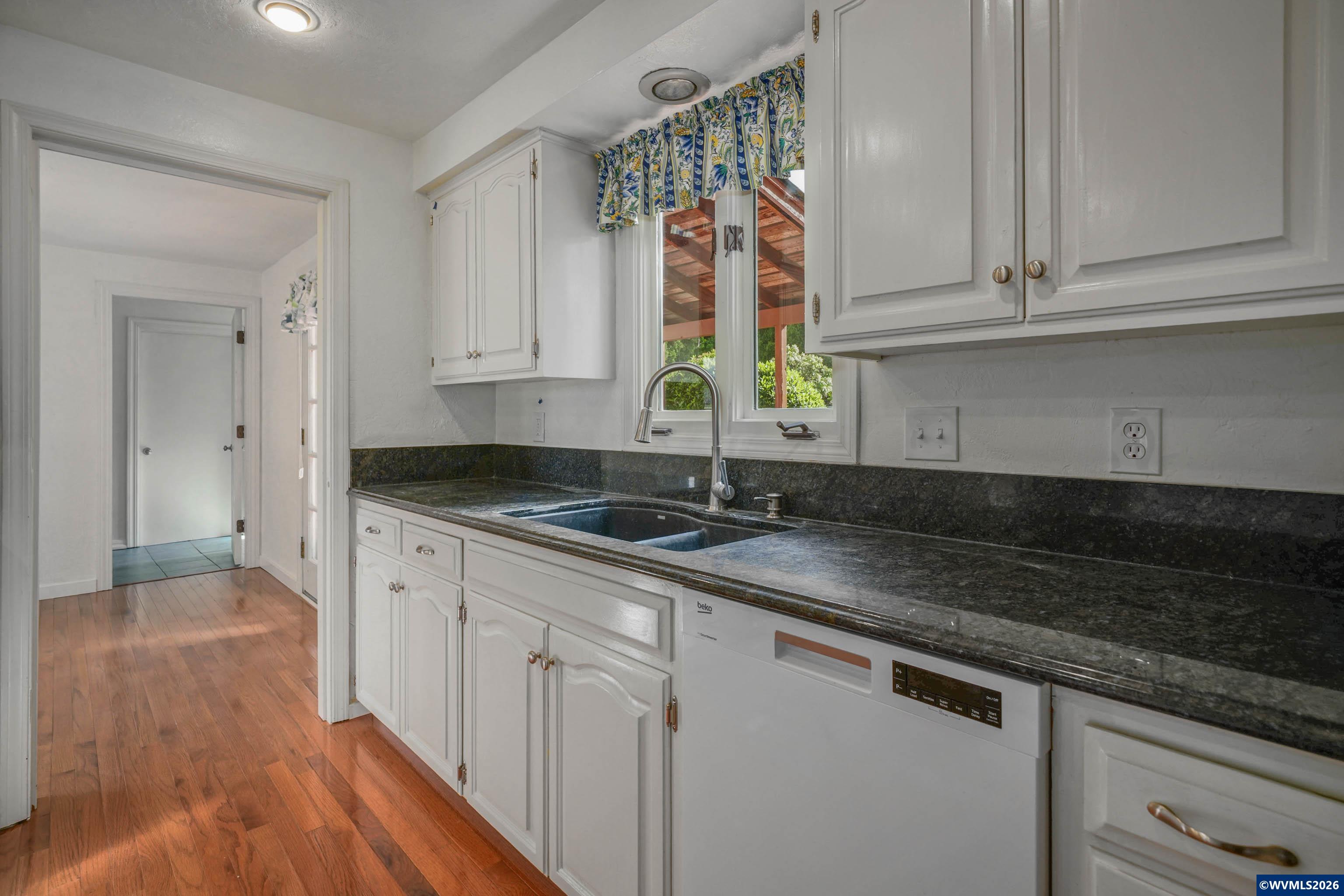 220 Northwest Downy Drive Sublimity, OR 97385 - Photo 7 of 47 a kitchen with granite countertop a sink and cabinets