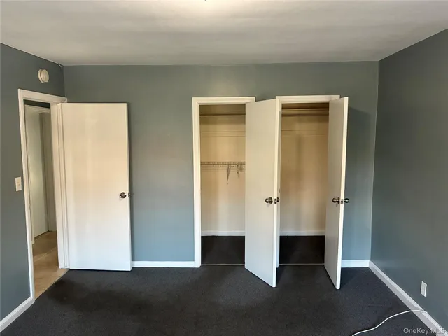 a view of an empty room with wooden floor and cabinet