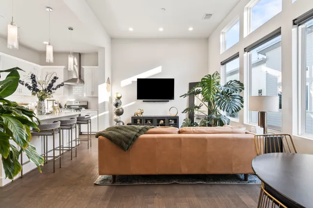 a living room with furniture a flat screen tv and a large window