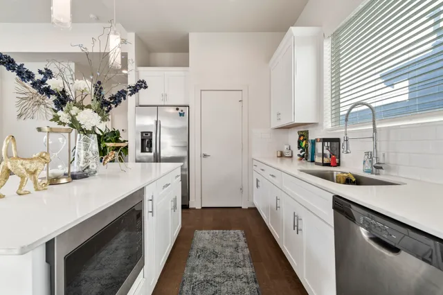 a kitchen with stainless steel appliances kitchen island granite countertop a sink stove and refrigerator