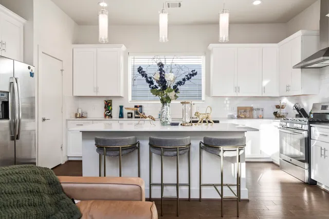 a kitchen with stainless steel appliances granite countertop a sink and a refrigerator