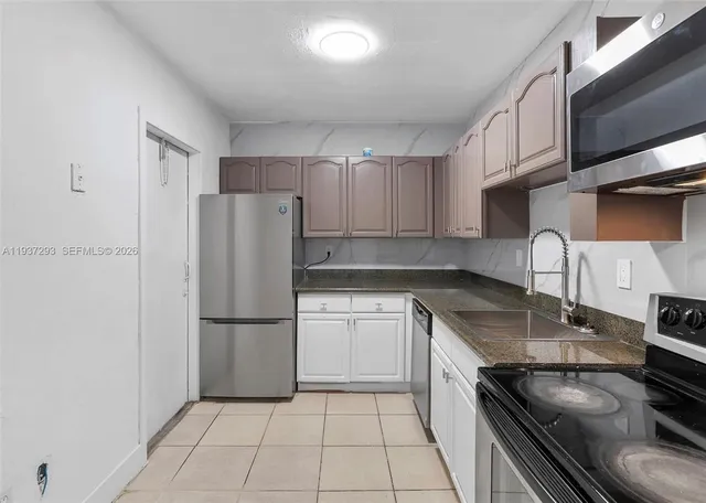 a kitchen with a refrigerator a sink and cabinets
