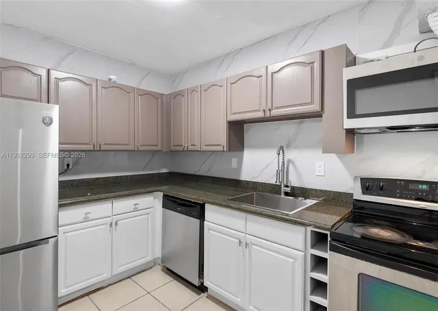 a kitchen with white cabinets and stainless steel appliances