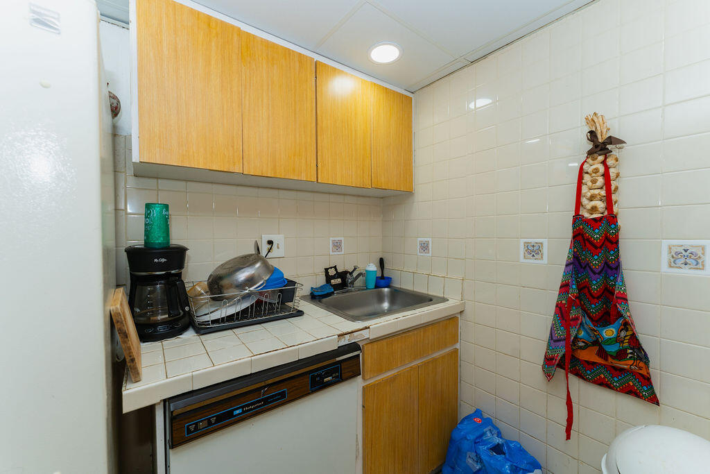 777 Southwest 9th Avenue, Unit 409 Miami, FL 33130 - Photo 12 of 32 a kitchen with stainless steel appliances a sink a stove and a wooden floor