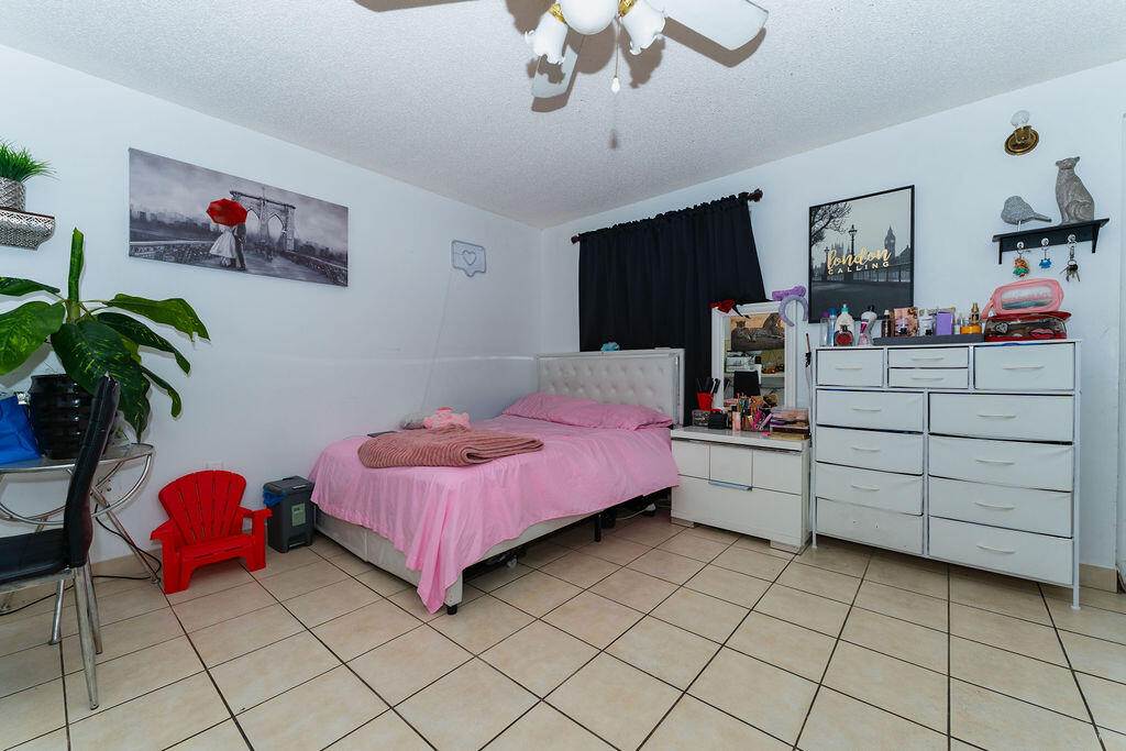 777 Southwest 9th Avenue, Unit 409 Miami, FL 33130 - Photo 18 of 32 a bedroom with a bed and a chandelier