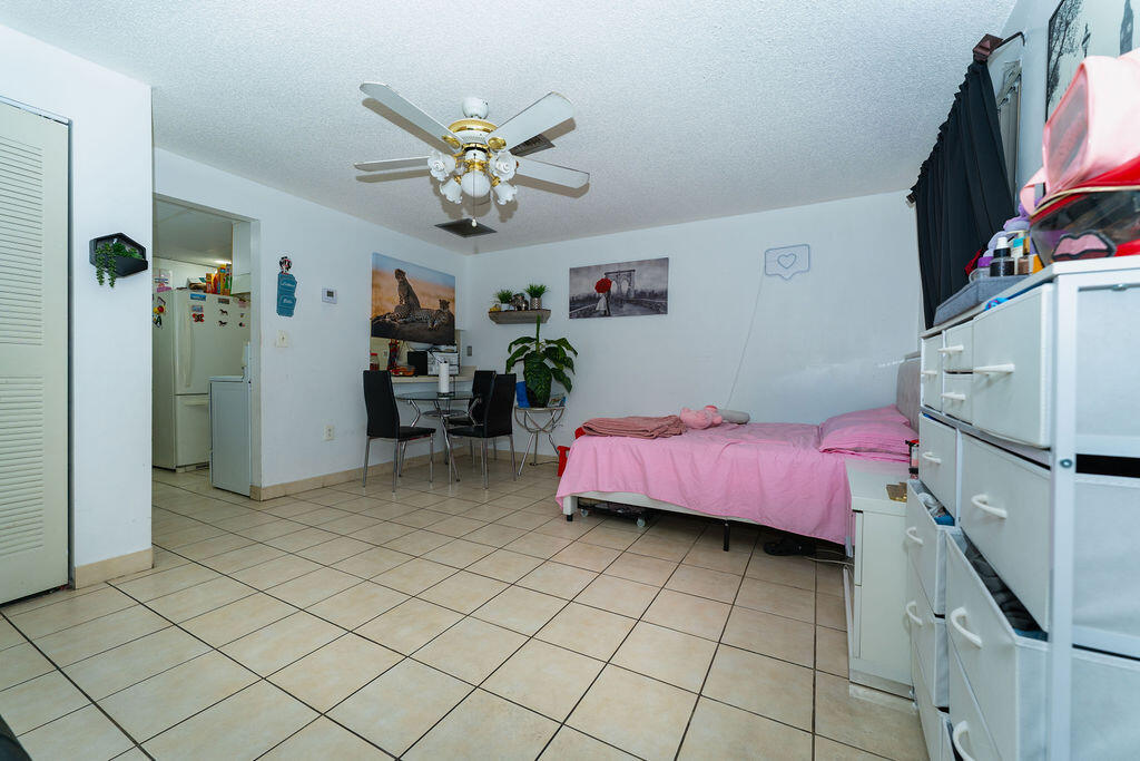 777 Southwest 9th Avenue, Unit 409 Miami, FL 33130 - Photo 19 of 32 a bedroom with a bed and a chandelier
