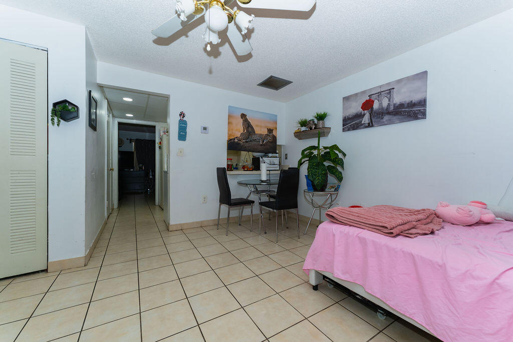 777 Southwest 9th Avenue, Unit 409 Miami, FL 33130 - Photo 24 of 32 a bedroom with furniture and a chandelier