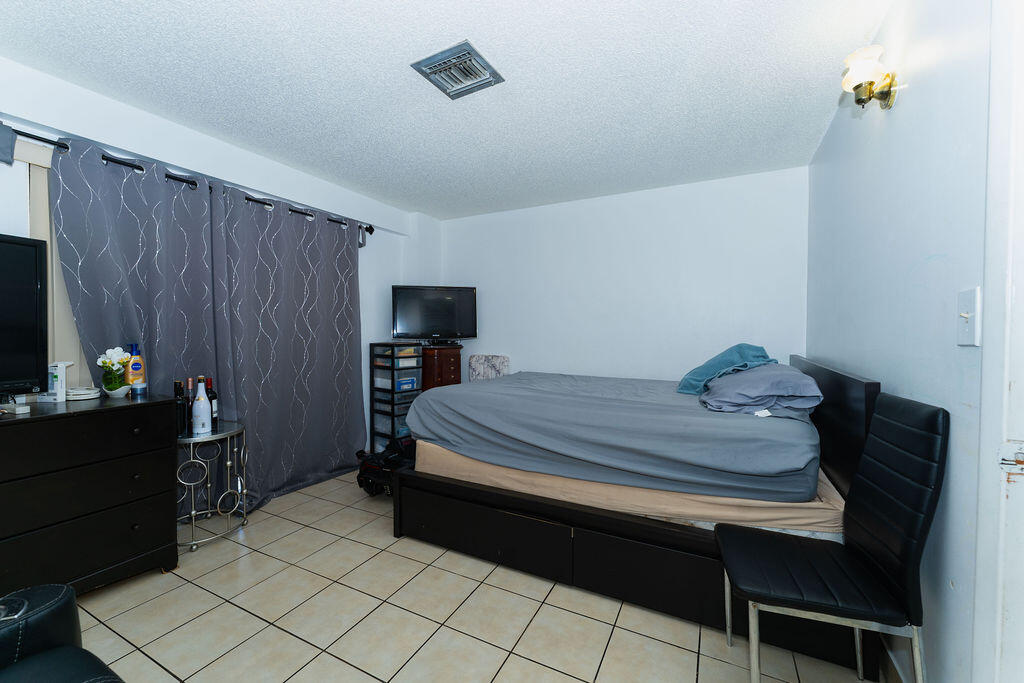 777 Southwest 9th Avenue, Unit 409 Miami, FL 33130 - Photo 7 of 32 a bedroom with a bed and a lamp on dresser