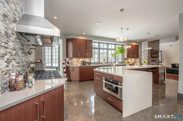a kitchen with stainless steel appliances kitchen island granite countertop a stove a sink and a refrigerator