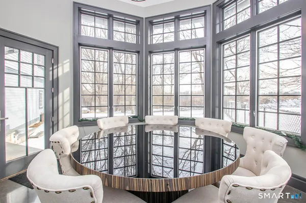 a living room with furniture and two large windows