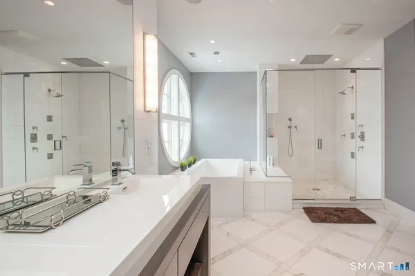 a spacious bathroom with a double vanity sink a mirror and a shower