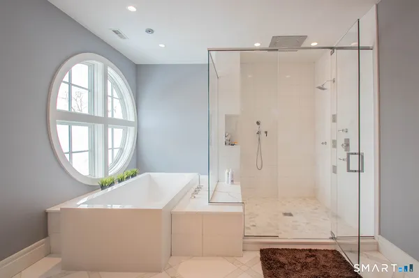 a bathroom with a granite countertop bathtub a shower and a mirror