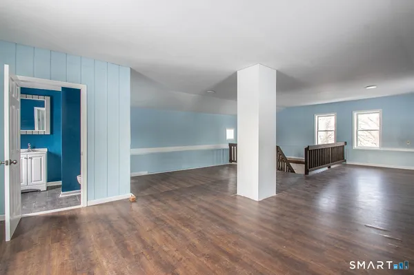 a view of empty room with wooden floor and window