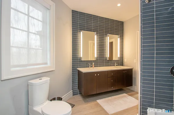 a bathroom with a granite countertop toilet sink and mirror